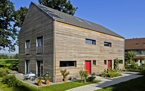 Maisons individuelles jumelles à la façade en mélèze non traité, du côté de l’entrée.