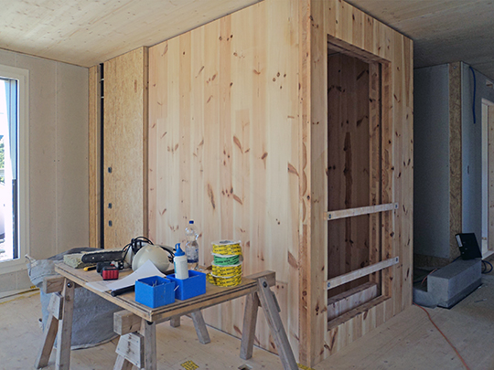 Unverkleideter Liftschacht aus Holz in der Bauphase, seitlich fotografiert.