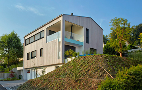 Façade en bois avec une lasure grise à effet vieilli d'une maison Renggli