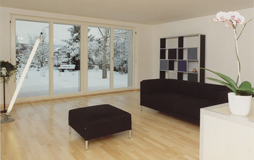 Möblierter Wohnraum mit Sicht in den verschneiten Garten