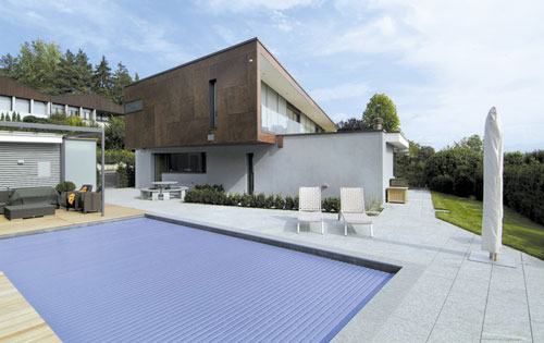 Pool mit geschlossener Abdeckung, Holzdeck- und Plattenumrandung.
