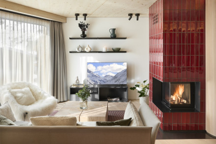 Wohnzimmer mit Ofen aus roten Kacheln.