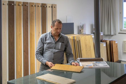 Bruno Kronenberg, Leiter Bodenbeläge bei einer Beratung im Ausstellungsraum für Parkett und Bodenbeläge.