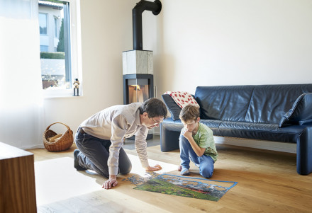 Wohnzimmer mit Vater und Sohn beim Puzzlespielen