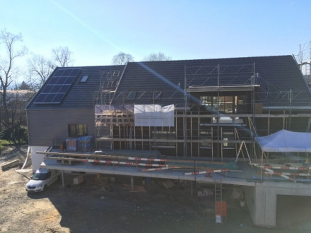 Laufends Bauprojekt. Linker, abgerüsteter Teil in Holzbauweise, rechts, noch eingerüstet, der Massivbau.