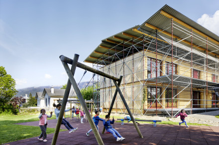 Kinder spielen auf dem Spielplatz vor ihrem Schulhaus.