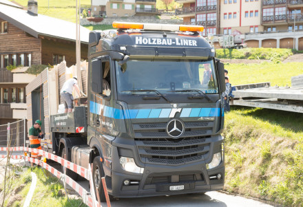 LKW mit Holzelementen beladen auf schmaler Strasse