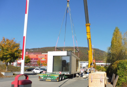 Pneukran platziert Modul auf LKW.