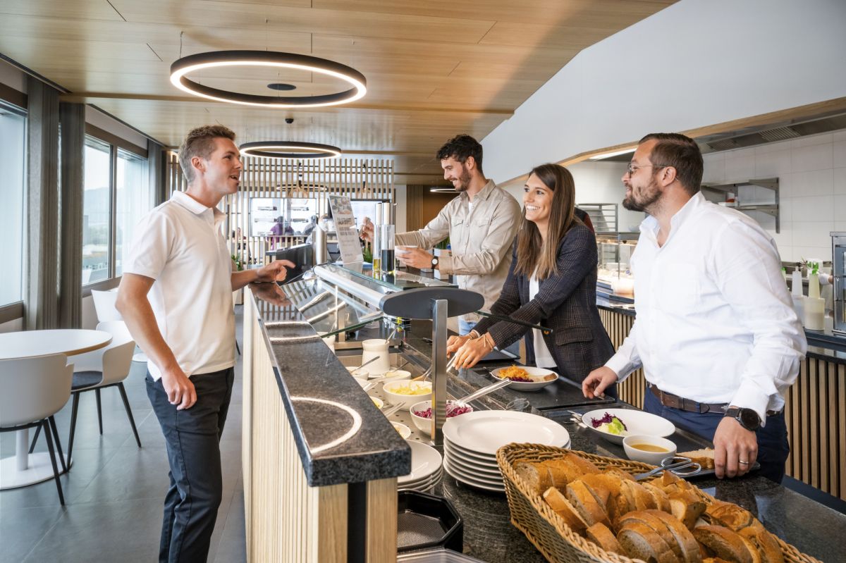 Personen bedienen sich am Salatbuffet und sprechen miteinander