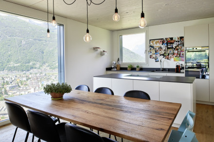 Küche mit Esstisch im Vordergrund und Blick durchs Fenster auf Bellinzona.