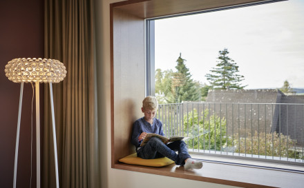 Sitzfenster mit Aussicht und Junge beim Lesen