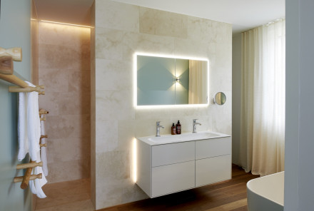 Badezimmer mit bodenebenener Dusche und indirekt beleuchtetem Lavabo-Spigel