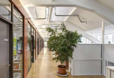 Korridor in ausgebautem obersten Stock mit sichtbaren Frischluftrohren zu den Zimmern