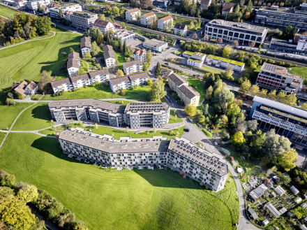 Luftaufnahme der Überbauung mit den zwei Gebäudezeilen mit gut sichtbarem Binnenraum als Quartierplatz dazwischen