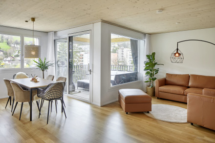 Wohnung mit Parkettboden und Holzdecke mit Blick vom Wohn-/Essraum in Richtung Loggia