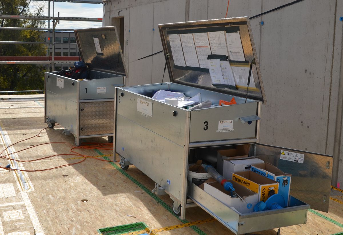 Baustelle mit fahrbaren Boxen für Material wie Schrauben, Nägel und Montagepläne .