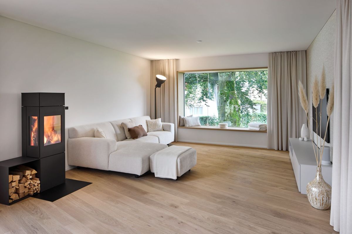 Wohnzimmer mit Feuer im Ofen und Sitzfenster