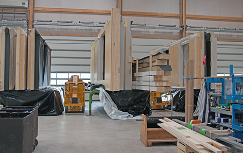 Trois plates-formes avec des éléments de murs dans le hall de l’usine.
