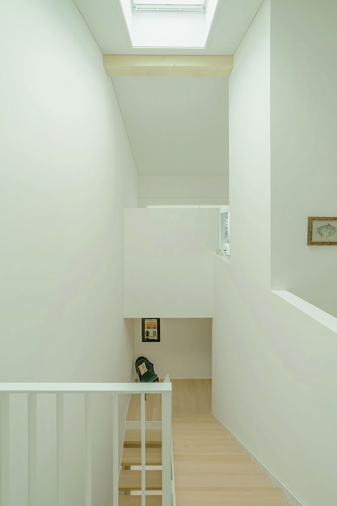 Cage d'escalier lumineuse avec escalier en bois et lanterneau