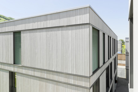 Le lotissement Bornfeld à Olten avec une couverture en tôle et une enveloppe en bois verticale.