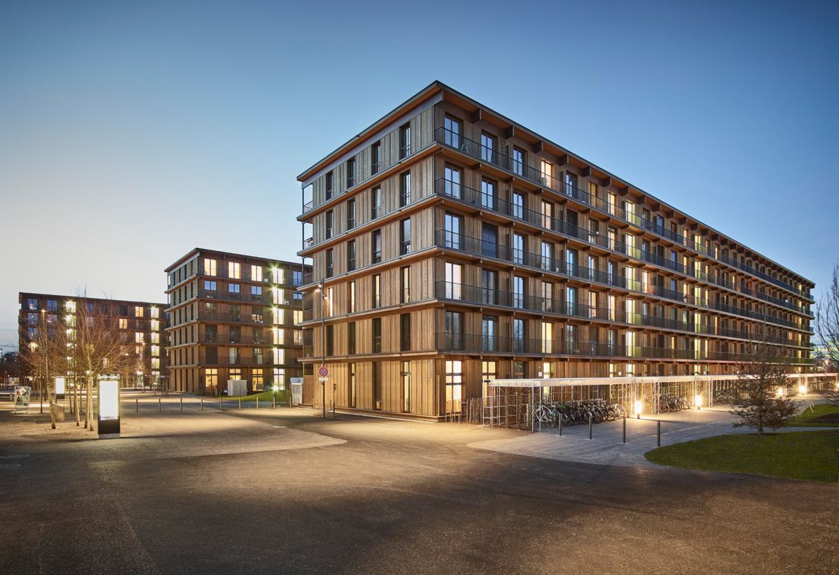 Trois immeubles d’habitation de six étages aux façades de bois sombre situés à Zurich.