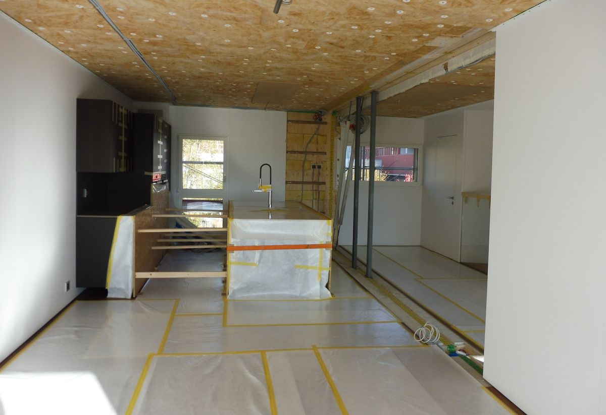 Le module de la cuisine sans meubles ni objets. Les lames de parquet posées sur les jointures des modules ont été enlevées.