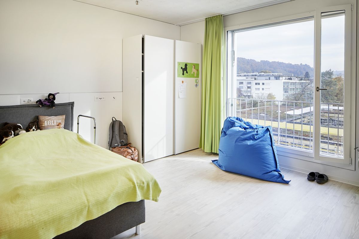 Chambre d'enfant avec lit, armoire et grande fenêtre