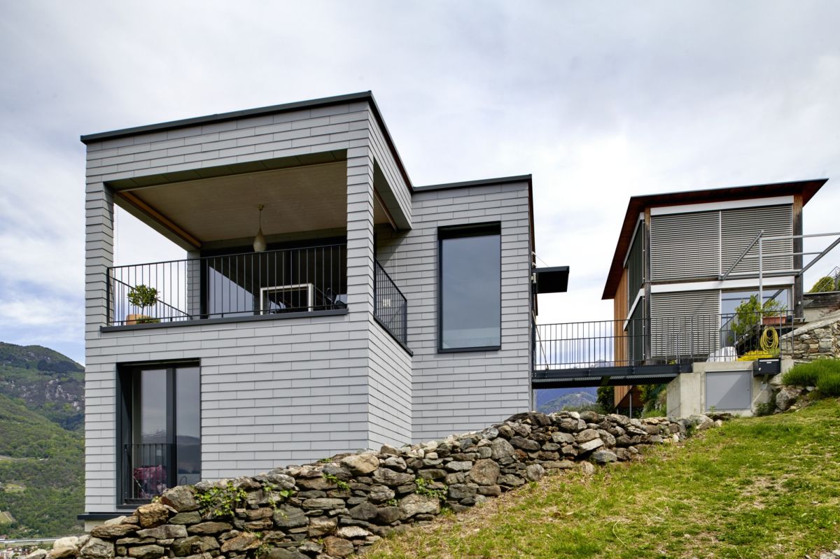 Vue du bâtiment de deux étages sur une pente raide avec pont d'accès et terrasse.