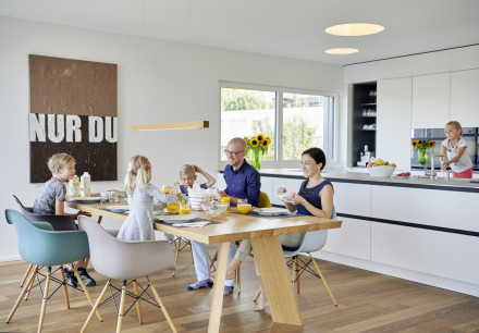 Famille au petit déjeuner dans la salle à manger de la grande cuisine ouverte