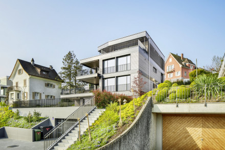 Immeuble d'habitation de quatres étages en bois avec façade en bois et des plaques Alucobond, jardin et garage