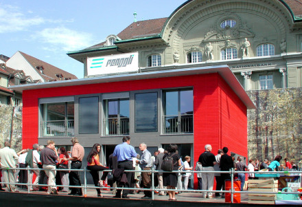 Maison solaire de Renggli avec visiteurs devant la Banque Nationale Suisse à Berne.