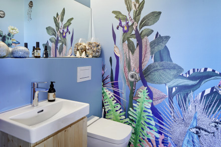 Salle de bains avec grand miroir et papier peint