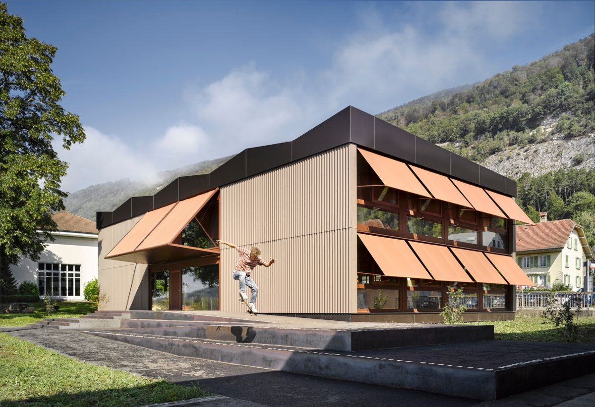 Bâtiment scolaire de deux étages avec stores à projection abaissés.