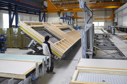 Collaborateur tourne un élément de paroi avec la table papillon dans l’usine Renggli.