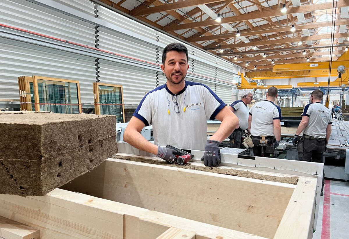 Un collaborateur de la production d’éléments place l’isolation dans un élément de paroi.