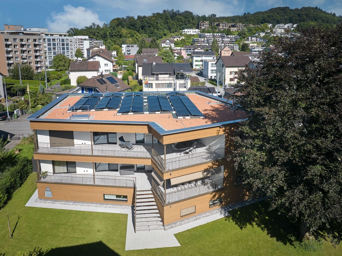 Immeuble collectif de trois étages vu d'en haut, avec une installation photovoltaïque sur le toit