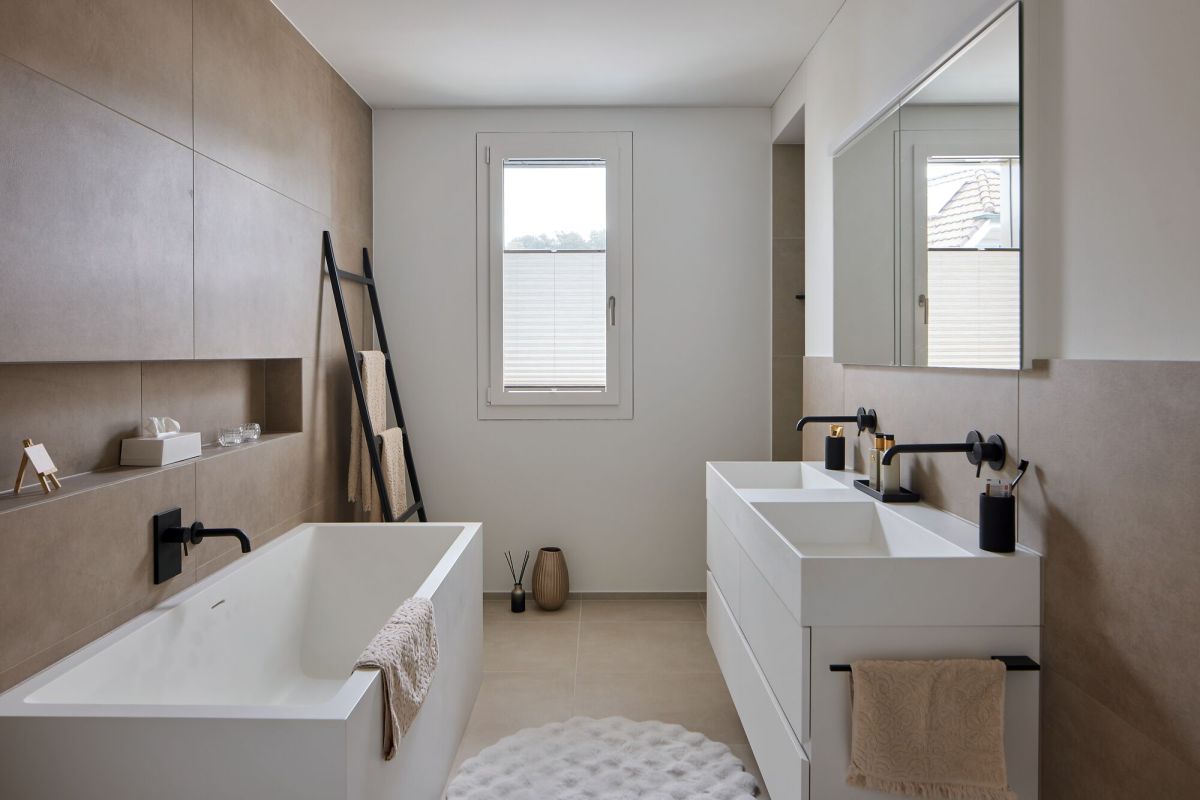 Salle de bains avec baignoire, deux lavabos aux teintes terreuses