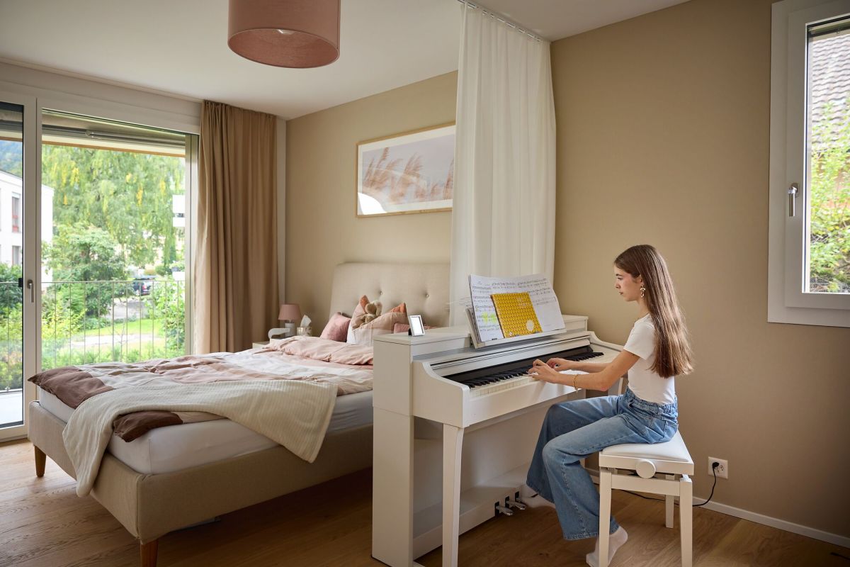 Une jeune femme joue du piano dans sa chambre