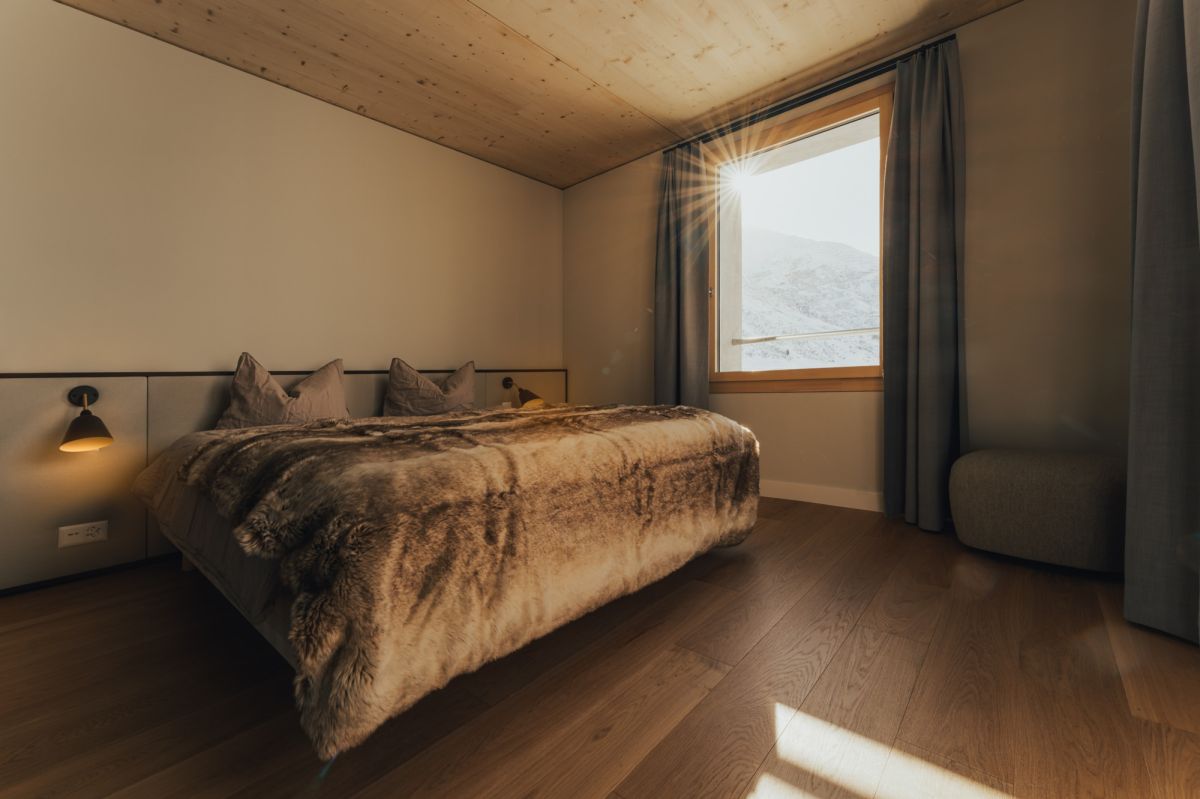 Camera da letto con pavimento in parquet e soffitto in legno